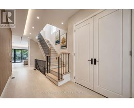 A spacious hallway with a staircase and white walls.
