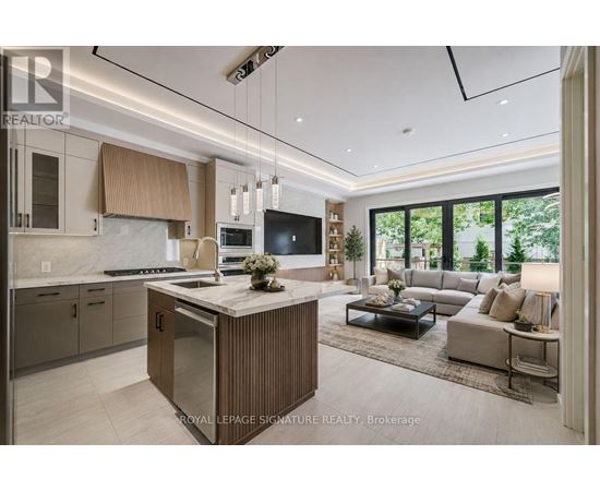 A modern kitchen with a central island and a view of the backyard.