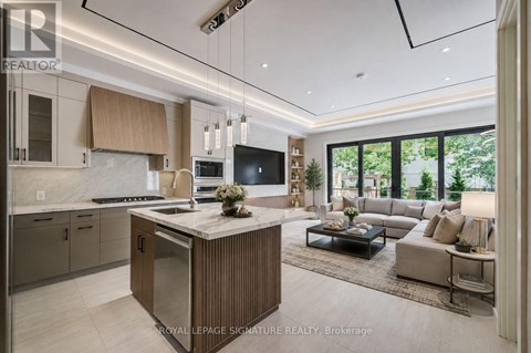 A modern kitchen with a central island and a view of the backyard.