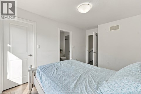 A bedroom with a bed, dresser, and mirror.