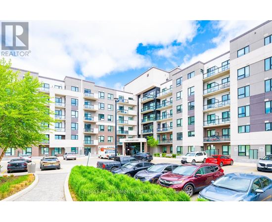 A large apartment complex with a parking lot in front.