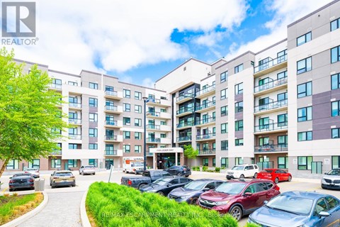 A large apartment complex with a parking lot in front.