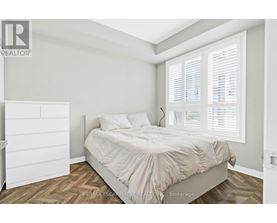A bedroom with a bed, nightstand, and window with blinds.