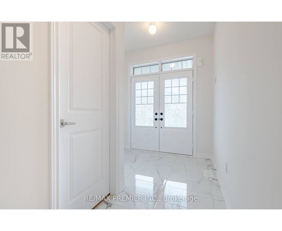 A white door with a glass window is in a room with white walls.