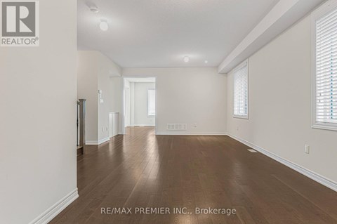 A spacious room with wooden floors and white walls.