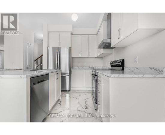A kitchen with white cabinets and marble countertops.