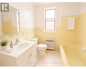 A bathroom with a white sink, toilet, and bathtub.
