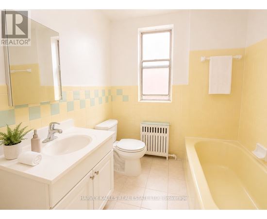 A bathroom with a white sink, toilet, and bathtub.