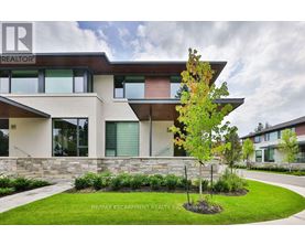 A modern house with a stone wall and a tree in front.