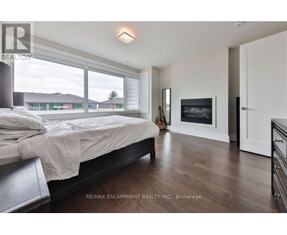 A bedroom with a large bed and a fireplace.