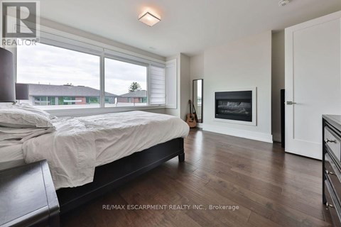 A bedroom with a large bed and a fireplace.