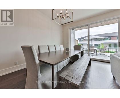 A modern dining room with a wooden table and chairs.