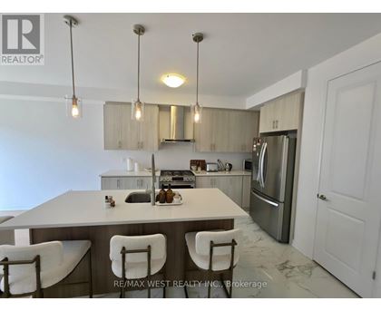 A kitchen with a table and chairs in the foreground and a refrigerator in the background.