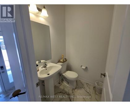 A white bathroom with a sink, toilet and mirror.