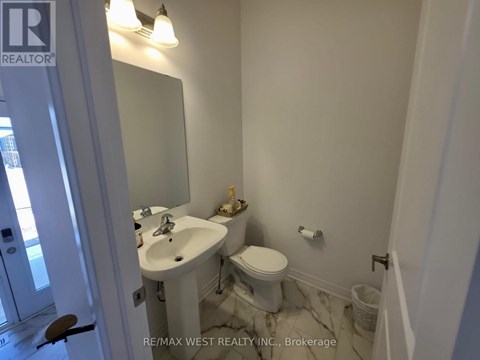 A white bathroom with a sink, toilet and mirror.