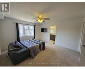 A bedroom with a bed, a ceiling fan, and a window with curtains.