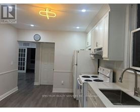 A kitchen with a white stove and cabinets.