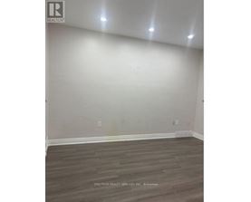 A room with wooden flooring and white walls.