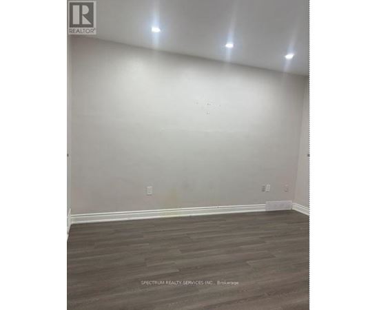 A room with wooden flooring and white walls.