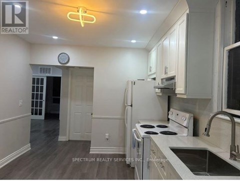 A kitchen with a white stove and cabinets.