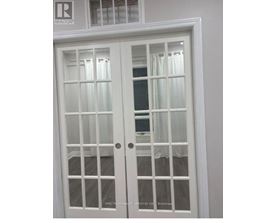 A white double door with glass panels and a window above it.