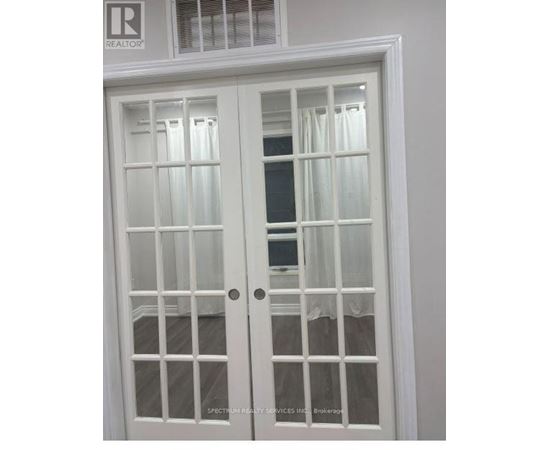 A white double door with glass panels and a window above it.