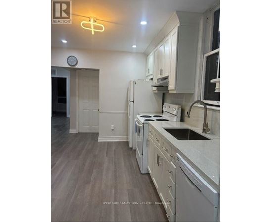 A kitchen with white cabinets and a stove top oven.