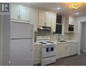 A kitchen with white appliances and cabinets.