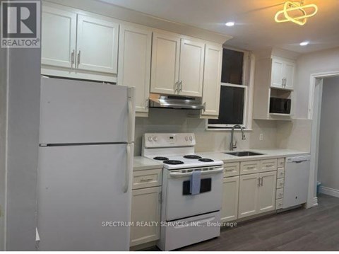A kitchen with white appliances and cabinets.