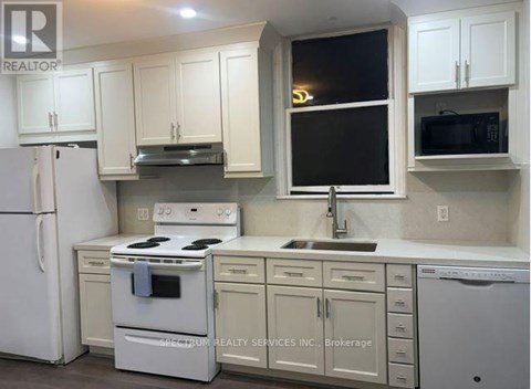 A white kitchen with a refrigerator, stove, and microwave.