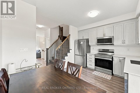A modern kitchen with white cabinets and stainless steel appliances.