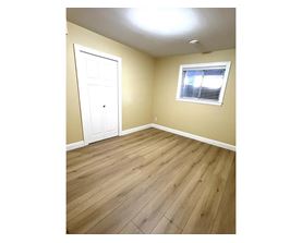 A room with a white door and a window with blinds.