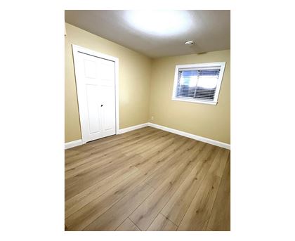 A room with a white door and a window with blinds.