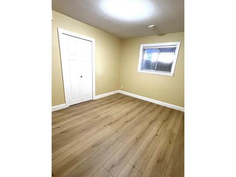 A room with a white door and a window with blinds.