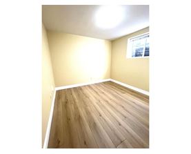 A room with wooden flooring and a window.