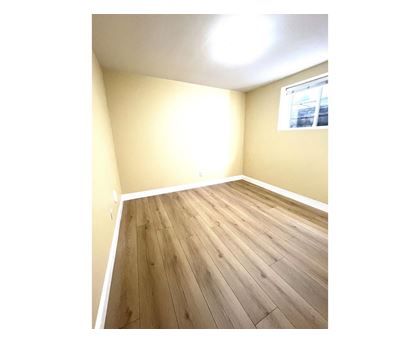 A room with wooden flooring and a window.