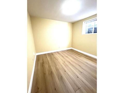 A room with wooden flooring and a window.