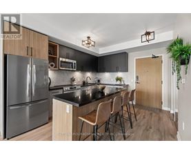 A modern kitchen with a black countertop and stainless steel appliances.