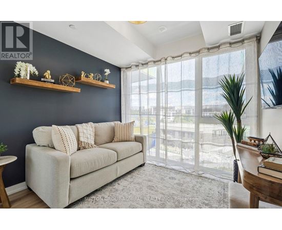 A living room with a grey couch and a large window.