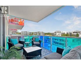 A balcony with a table and chairs overlooking a pool.
