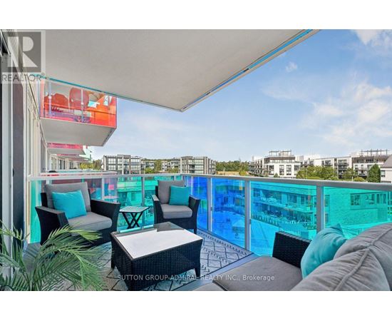 A balcony with a table and chairs overlooking a pool.