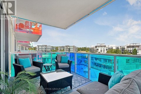 A balcony with a table and chairs overlooking a pool.