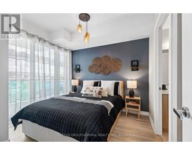 A bedroom with a large bed and a window with curtains.