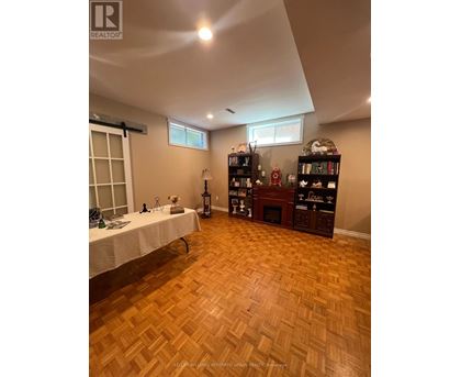 A room with wooden flooring and a table with a white cloth.