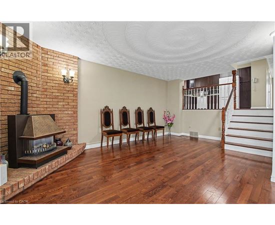 A living room with a fireplace and wood floors.
