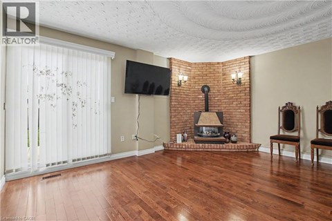 A living room with a fireplace and a flat screen TV.