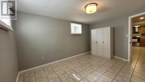 A room with a tiled floor and a white door leading to another room.