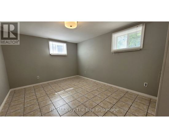 A room with a tiled floor and a window with blinds.