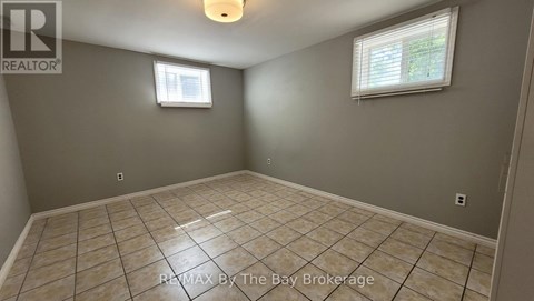 A room with a tiled floor and a window with blinds.