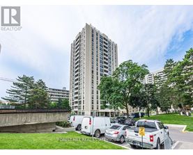A tall building with a parking lot in front of it.